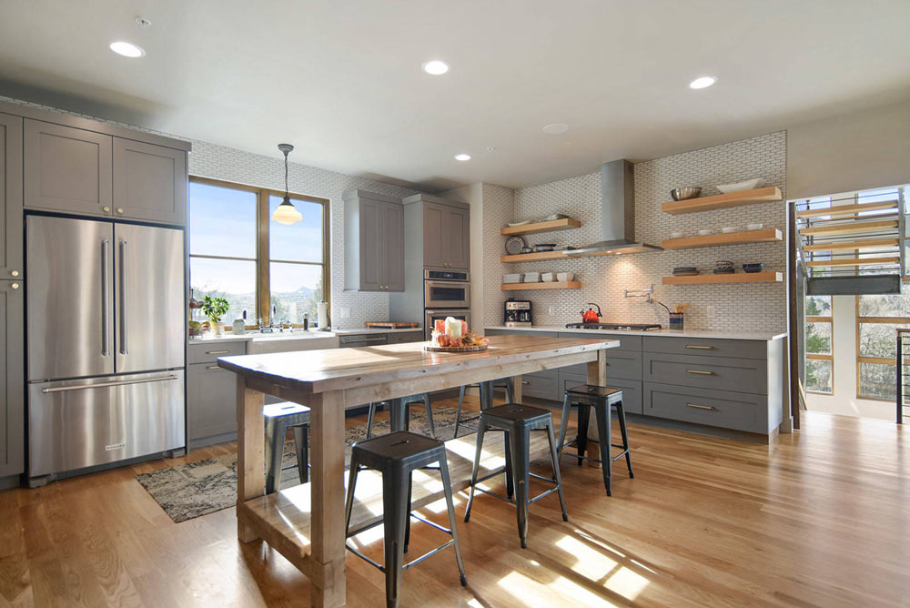 آشپزخانه بزرگ L شکل با کابینت های خاکستری و پنجره بزرگ