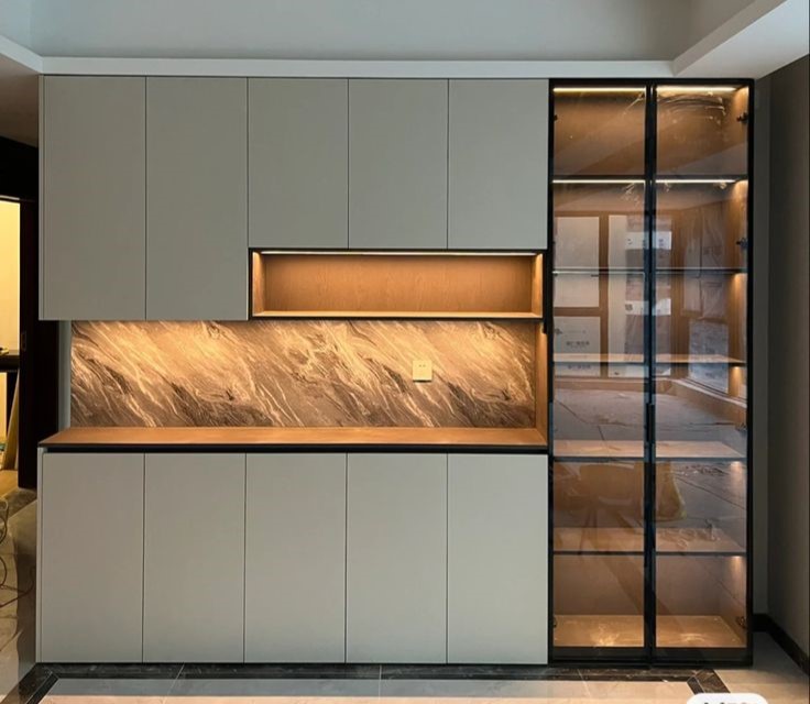 کابینت‌های مدرن با طراحی ساده و جزئیات شیشه‌ای، نورپردازی ملایم برای فضای آشپزخانه.