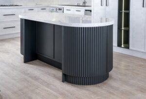 جزیره آشپزخانه به شکل بیضی با رویه سنگی روشن و گلدان تزئینی