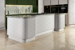 جزیره‌ی آشپزخانه با فرم منحنی و سطح کار سنگی خاکستری