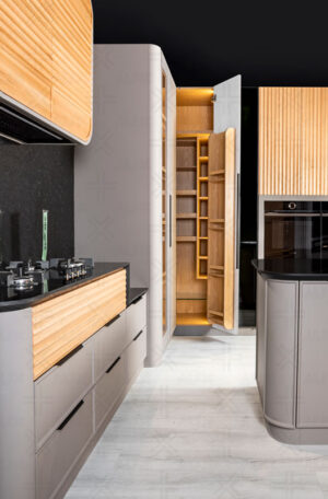 جزئیات کابینت آشپزخانه با طراحی منحنی، دستگیره مخفی و ترکیب چوب و رنگ خاکستری