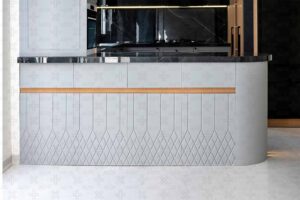 کابینت جزیره‌ای قوس‌دار با پوشش طوسی و سطح سنگی