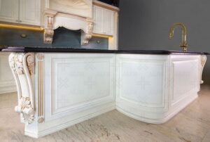 کابینت‌های منحنی با نقوش سنتی و جزئیات حکاکی‌شده در فضای آشپزخانه کلاسیک