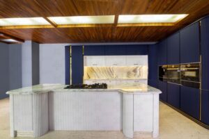 جزیره سفید با طراحی منحنی و صفحه رویه سنگی، همراه با اجاق گاز در مرکز فضا