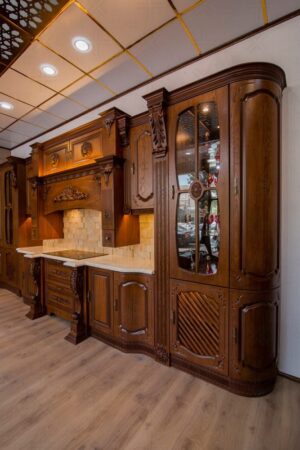 طراحی کابینت آشپزخانه با سبک سنتی و قفسه‌های شیشه‌ای تزئینی