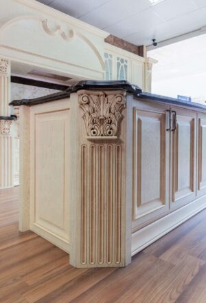 نمای نزدیک از جزیره کابینت آشپزخانه با طرح کلاسیک و ستون منبت‌کاری‌شده