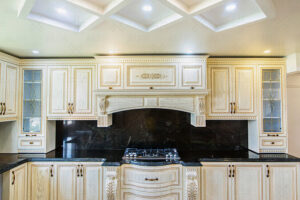 کابینت چوبی منبت‌کاری‌شده با ترکیب رنگ کرم و مشکی در فضای آشپزخانه