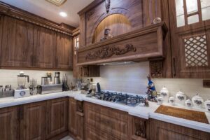 آشپزخانه با کابینت چوبی قهوه‌ای و طراحی منبت‌کاری‌شده