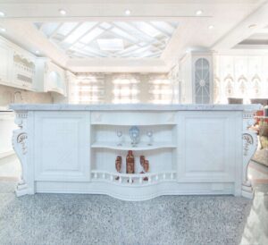 جزیره‌ آشپزخانه کلاسیک سفید با قفسه‌ دکوری و سنگ کابینت مرمر