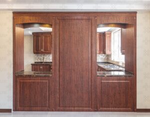 نمای کامل آشپزخانه با کابینت چوبی قهوه‌ای و تزئینات سنتی