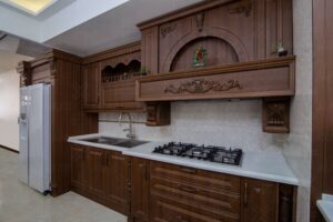 دکوراسیون آشپزخانه کلاسیک با رنگ قهوه‌ای گرم و سقف نورپردازی‌شده