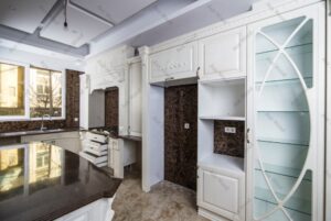 آشپزخانه با کابینت چوبی کلاسیک سفید و صفحه رویه قهوه‌ای براق