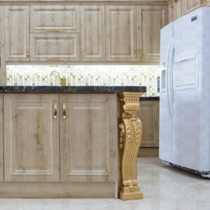 جزیره آشپزخانه با پایه‌های طلایی منقوش و سطح سنگی تیره