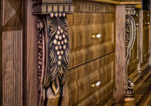 طراحی آشپزخانه با کابینت‌های چوبی تیره و تزئینات منبت