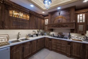 آشپزخانه با کابینت چوبی قهوه‌ای و طراحی منبت‌کاری‌شده