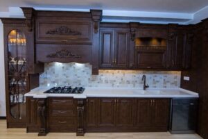 کابینت‌های سنتی چوبی با هود تزئینی و دیوار کاشی‌کاری‌شده