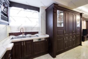 طراحی کلاسیک آشپزخانه با درب‌های چوبی و پنل شیشه‌ای نقش‌دار