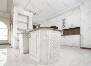 طراحی آشپزخانه با جزیره مرکزی و کابینت‌های قاب‌دار با منبت‌کاری