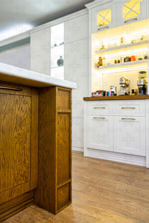 آشپزخانه نئوکلاسیک با کابینت‌های سفید و جزیره چوبی