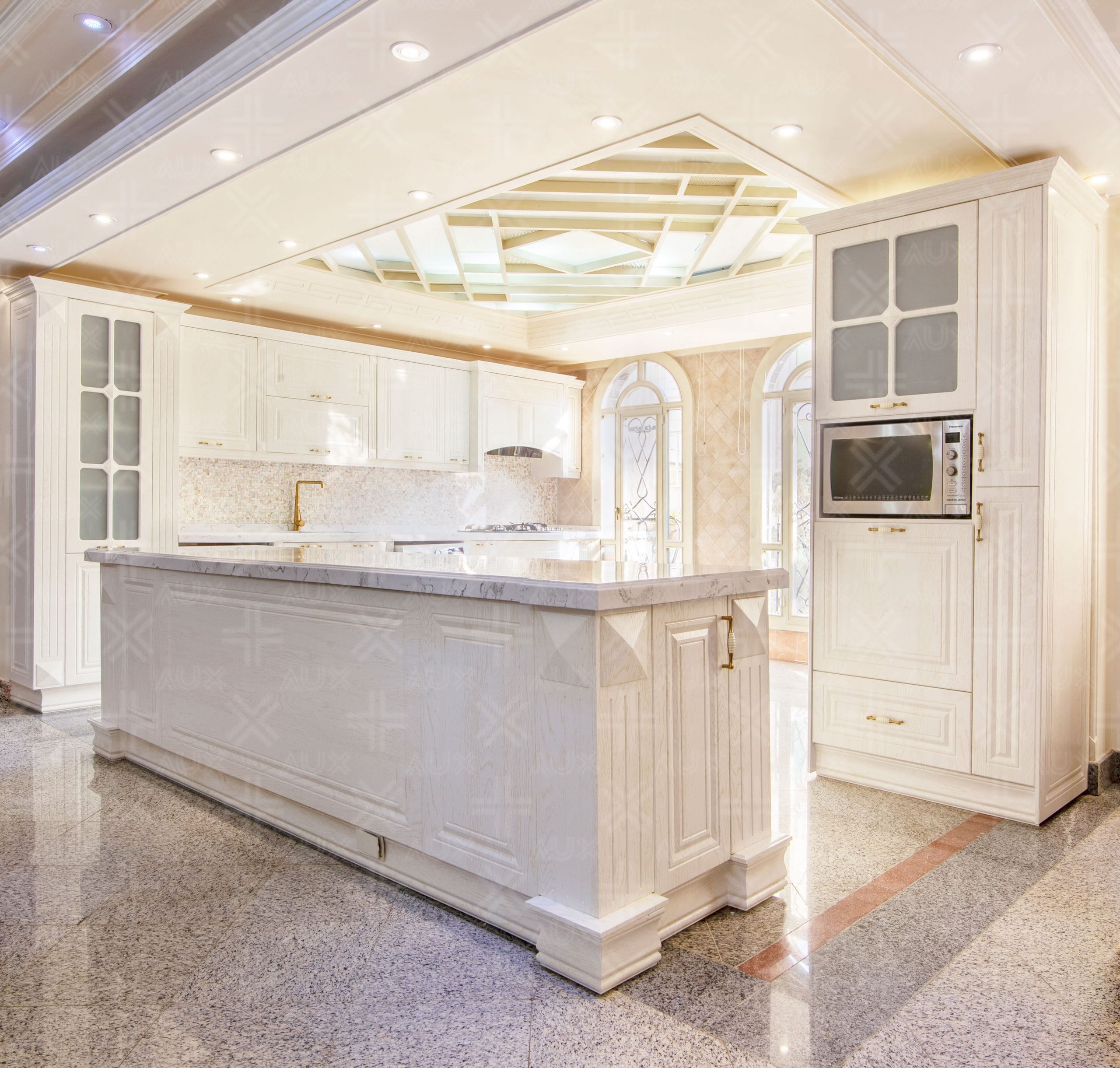 کابینت ممبران سفید با طراحی کلاسیک و جزیره‌ بزرگ مرمری در آشپزخانه لوکس