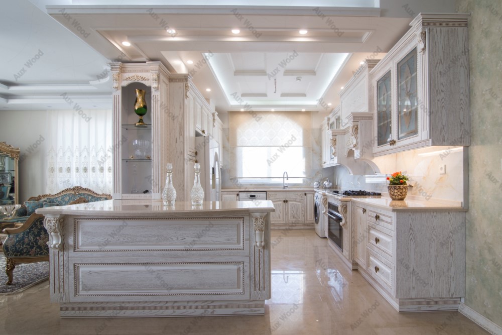 آشپزخانه کلاسیک با کابینت ممبران سفید و جزیره‌ی تزیین‌شده با ستون‌های منبت‌کاری