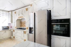 طراحی آشپزخانه کلاسیک با کابینت روکش چوب سفید و کاشی بین‌کابینتی طرح‌دار