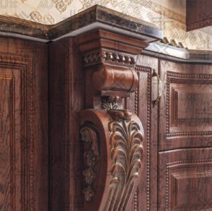 کابینت آشپزخانه روکش چوب تیره با منبت‌کاری ظریف و صفحه‌سنگ مشکی براق.