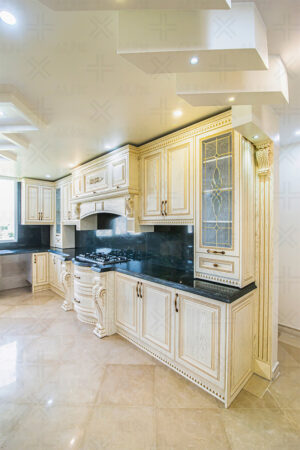 کابینت کلاسیک روکش چوب روشن با منبت‌کاری روی ستون‌ها و جزئیات ظریف.