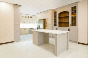 جزیره وسط آشپزخانه با صفحه سنگ سفید و کابینت‌های رنگ روشن