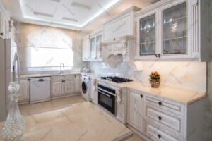 کابینت روکش چوب روشن با جزئیات منبت‌کاری و صفحه سنگ کرم