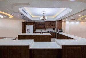 مدل کابینت چوبی آشپزخانه با جزئیات منبت‌کاری و صفحه سنگ