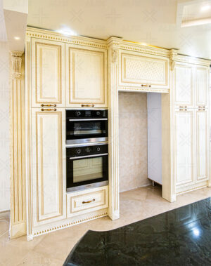 کابینت کرم‌رنگ با شیشه‌های طرح‌دار و نورپردازی سقفی