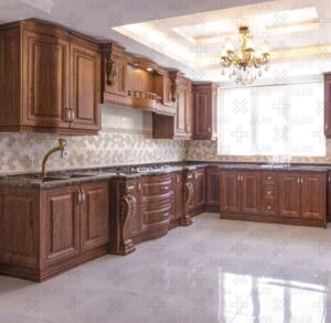 کابینت آشپزخانه روکش چوب تیره با منبت‌کاری ظریف و صفحه‌سنگ مشکی براق.