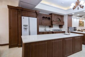 کابینت روکش چوب تیره با جزیره آشپزخانه و نورپردازی سقفی