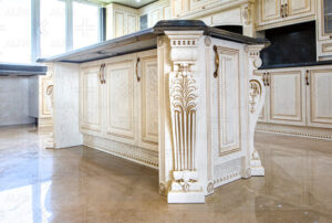 کابینت کلاسیک روکش چوب روشن با منبت‌کاری روی ستون‌ها و جزئیات ظریف.