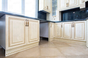 کابینت روکش چوب روشن با دستگیره‌های فلزی و صفحه‌سنگ یکپارچه