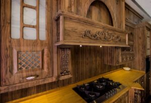 طراحی آشپزخانه کلاسیک با کابینت روکش چوب و ویترین شیشه‌ای