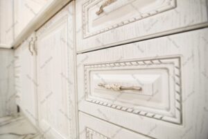 طراحی داخلی آشپزخانه با کابینت روکش چوب سفید و جزئیات منبت‌کاری