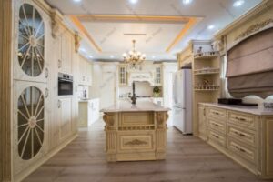 طراحی آشپزخانه کلاسیک با کابینت روکش چوب رنگ کرم و منبت‌کاری